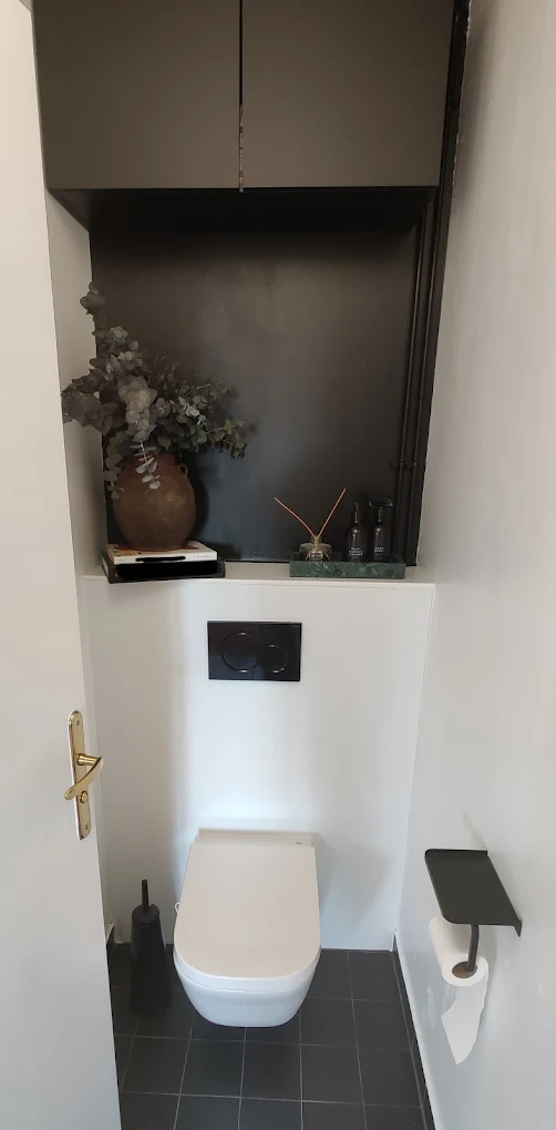 Toilettes renovees avec finition noire et blanche, chantier propre